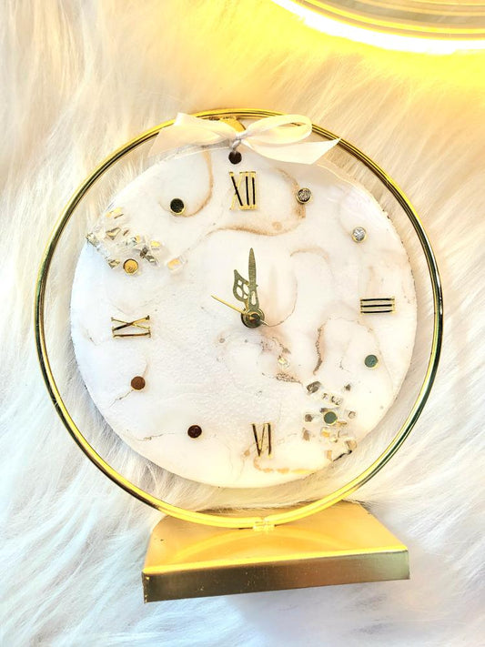 Decorative clock with marble design and gold accents on a white background