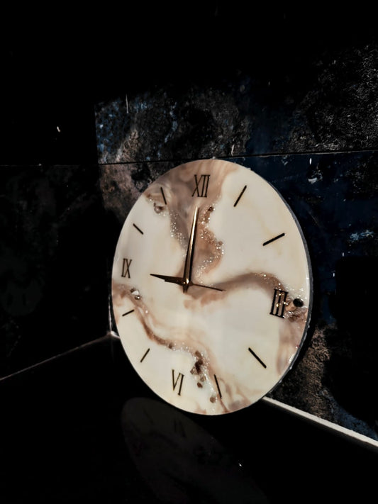 a resin wall clock with earthy colors and swirly marble like patterns in a dark interior 