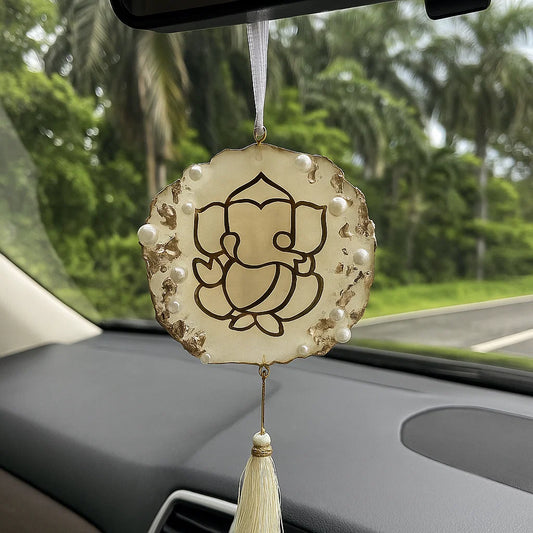 Decorative car hanging with Ganesha symbol on a car dashboard