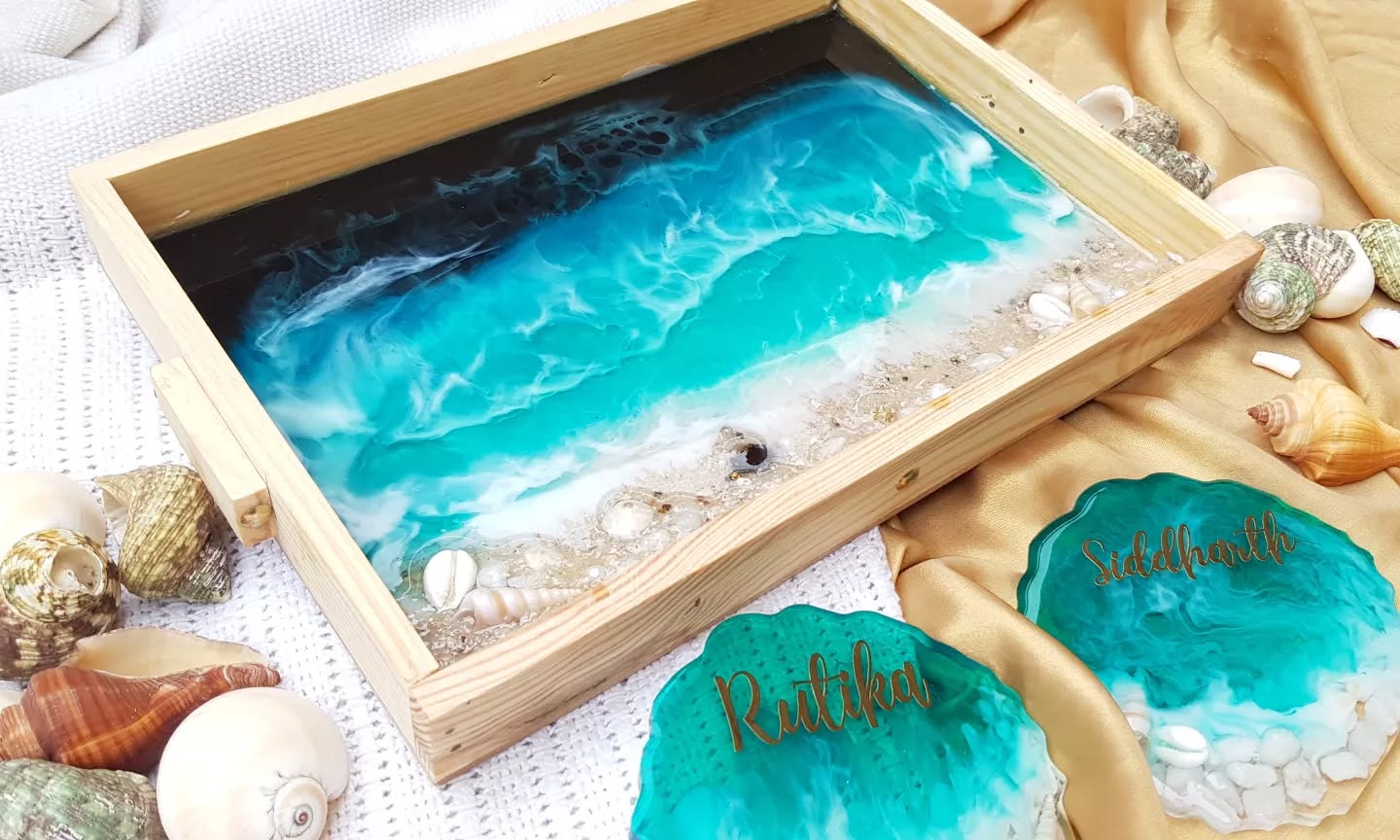 Decorative tray with resin ocean design and seashells on a textured surface with 2 personalized coasters
