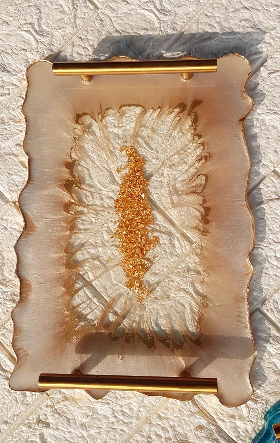 Decorative tray with gold accents on a textured white surface